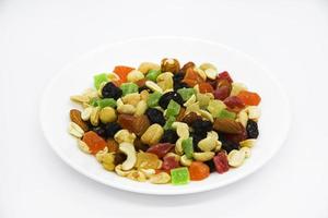 Nut mixture and dried fruits on a white plate. photo