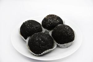 Black chocolate brownies on a white plate. Delicious round chocolate cakes. A sweet snack. photo