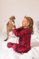 a happy little girl received a cute kitten as a gift for the New Year. Christmas Morning. High quality photo