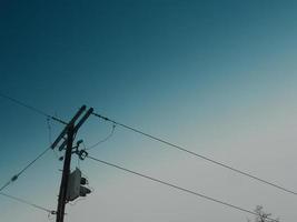 poste y líneas eléctricas de desvanecimiento azul foto