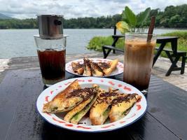 Iced coffee and chocolate toast with a lake view as a background photo