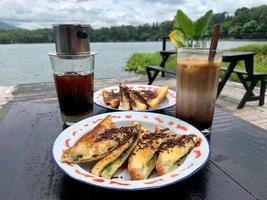 Iced coffee and chocolate toast with a lake view as a background photo