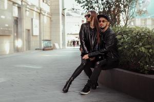 Sexy couple posing on a bench and looks away in the street photo