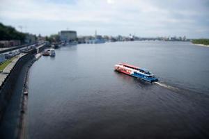 a passenger boat with people floats on the river, the effect of a micro-city. photo