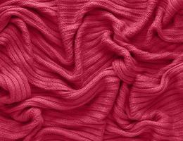Texture of smooth knitted sweater with pattern. Handmade knitting wool or cotton fabric texture. Background of Large knit pattern with knitting needle or crochet. Color Of The Year 2023 - Viva Magenta photo