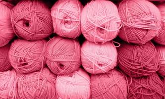 Yarn Balls Wool in a Fabric Shop. Background from colored acrylic yarn. Skeins of thread close-up. Materials for needlework, for knitting and crocheting. Color Of The Year 2023 - Viva Magenta photo