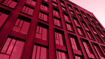 Red background made of Exterior modern house object. Architectural detail of skyscraper, close-up on windows. Real estate, residential apartments and offices. Color Of The Year 2023 - Viva Magenta photo