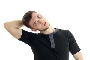 guy in a black t-shirt holds a hand near his head and posing photo