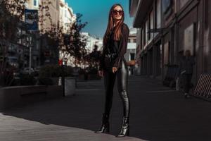 sexy lady in leather suit stands in the city photo