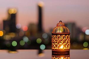 farolillos dorados con cielo del amanecer y fondo claro de la ciudad para la fiesta musulmana del mes sagrado del ramadán kareem. foto