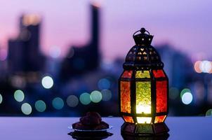 Lantern with dusk sky and city bokeh light background for the Muslim feast of the holy month of Ramadan Kareem. photo