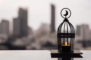 Lantern that have moon symbol on top with city background for the Muslim feast of the holy month of Ramadan Kareem. photo