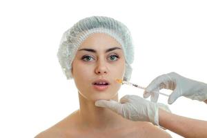 Portrait of a young girl without makeup in a special hat which the surgeon makes injection photo