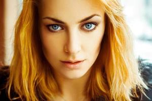 Warm close up portrait of gorgeous and seriuous  adult girl with blue eyes photo