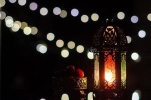 linterna y dátiles con luz bokeh en fondo oscuro para la fiesta musulmana del mes sagrado de ramadán kareem.