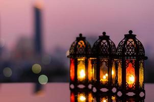 farolillos con cielo al atardecer y fondo de luz bokeh de la ciudad para la fiesta musulmana del mes sagrado del ramadán kareem. foto