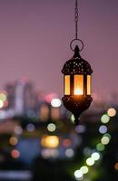 Hanging lantern with night sky and city bokeh light background for the Muslim feast of the holy month of Ramadan Kareem. photo
