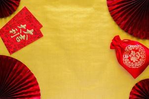 el concepto de fondo del año nuevo chino con paquetes de sobres rojos o la palabra ang bao significa auspicio y la palabra bolsa roja significa riqueza en el fondo del espacio vacío dorado con ventiladores rojos.