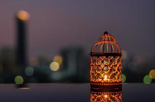 Golden lanterns with dusk sky and city bokeh light background for the Muslim feast of the holy month of Ramadan Kareem. photo