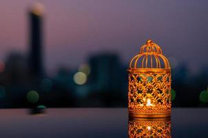 Golden lanterns with dusk sky and city bokeh light background for the Muslim feast of the holy month of Ramadan Kareem. photo