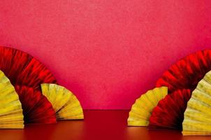 Selective focus on some golden and red oriental fans with red background for Chinese new year concept. photo