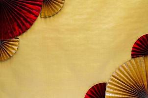 Chinese new year background concept with red and gold oriental fans on golden empty space background. photo