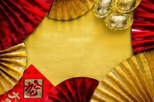 concepto de fondo de año nuevo chino con paquete de sobre rojo o palabra ang bao significa riqueza suerte y lingotes palabra significa riqueza en el fondo del espacio vacío de oro con ventiladores. foto