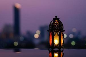 farol con cielo al atardecer y fondo de luz bokeh de la ciudad para la fiesta musulmana del mes sagrado del ramadán kareem. foto