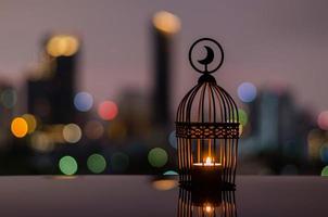 Lantern with dusk sky and city bokeh light background for the Muslim feast of the holy month of Ramadan Kareem. photo