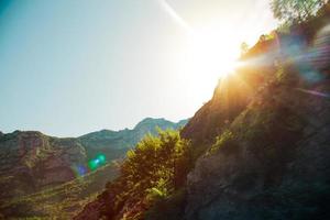 Moutains and glare from sun streaming through them photo