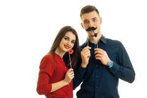 alegre pareja joven en el estudio con risa de bigote de papel foto