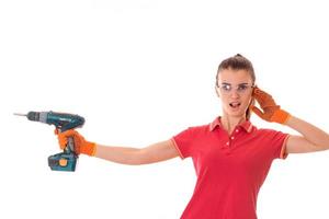 young funny brunette woman builder in uniform with glasses and drill in her hands make reovations isolated on white background photo