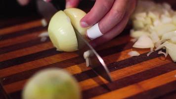 close up of man cuts onions on a cutting board video
