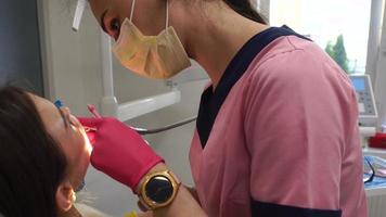 tandarts in unform behandelt meisjes tanden in kliniek video