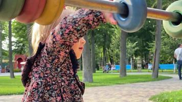 charming little blonde toddler girl plays with multicolor circles on a playground video