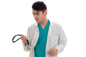 young man doctor posing in uniform with stethoscope isolated on white background in studio photo