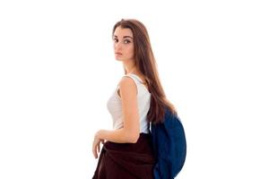 young girl with a big Briefcase on the back worth turning sideways to the camera isolated on white background photo