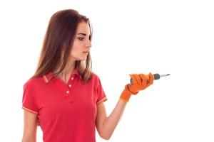 beautiful young slim builder girl makes renovations with screwdriver isolated on white background photo