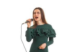 funny young girl in green dress singing a karaoke photo