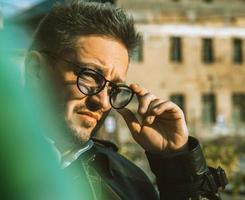 close up portrait of adult male in sunglasses looking away outdoors photo