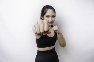 Hermosa luchadora asiática deportiva entrena boxeo en estudio sobre fondo blanco. concepto de artes marciales foto