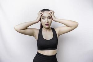 A portrait of an sporty Asian woman wearing a sportswear isolated by white background looks depressed photo