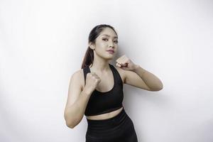 Hermosa luchadora asiática deportiva entrena boxeo en estudio sobre fondo blanco. concepto de artes marciales foto