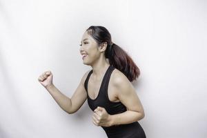 A sporty Asian woman wearing sportswear is running, isolated by white background photo