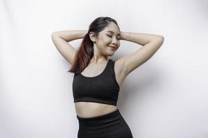 Smiling sporty Asian woman wearing sportswear is relaxing after working out photo