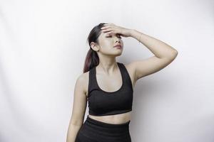 un retrato de una mujer asiática deportiva que usa ropa deportiva aislada por un fondo blanco parece deprimido foto