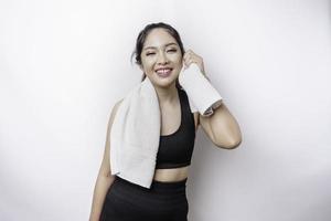 Sportive Asian woman posing with a towel on her shoulder, tired after workout photo