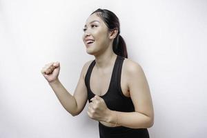 A sporty Asian woman wearing sportswear is running, isolated by white background photo