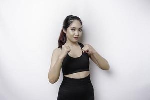 Hermosa luchadora asiática deportiva entrena boxeo en estudio sobre fondo blanco. concepto de artes marciales foto