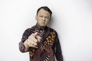 The angry and mad face of Asian man in batik shirt isolated white background. photo